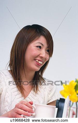 Closed Up Image of a Young Adult Woman Having a Cup of Coffee Looking Sideways, Smiling, Low Angle View View Large Photo Image Stock Photo - Closed Up Image of a Young Adult Woman Having a Cup of Coffee Looking Sideways, Smiling, Low Angle View. Fotosearch
