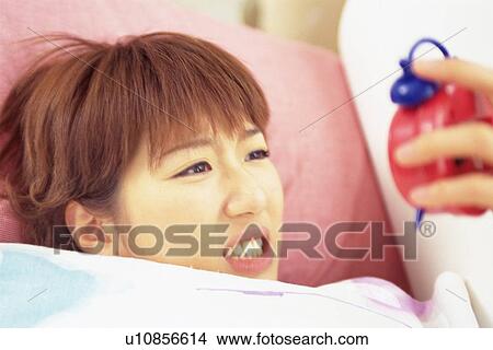 Picture - Closed Up Image of a Young Woman Staring At her Clock In Surprise, High Angle View. Fotosearch