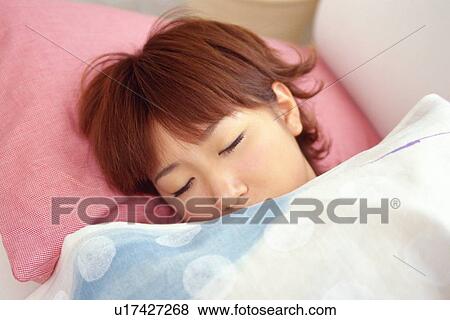 Stock Photo - Closed Up Image of a Young Woman Sleeping on a Pink Pillow, High Angle View. Fotosearch
