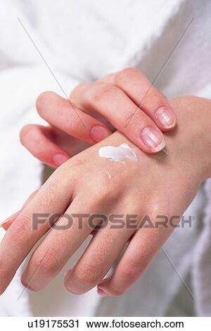 Stock Image - Closed Up Image of Female Hands Applying some Hand Cream, Front View, Differential Focus. Fotosearch