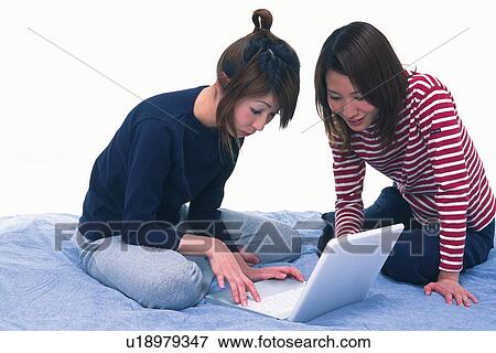 Two Young Adult Women Operating a Laptop, Side View View Large Photo Image Stock Photo - Two Young Adult Women Operating a Laptop, Side View. Fotosearch