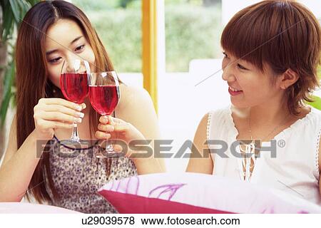 Two Young Adult Women with Clink Glasses Filled With Red Wine, Side View, High Angle View, Smiling View Large Photo Image Stock Photo - Two Young Adult Women with Clink Glasses Filled With Red Wine, Side View, High Angle View, Smiling. Fotosearch