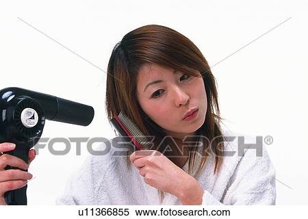 Young Adult Woman Blow Drying Hair While Looking Down, Front View View Large Photo Image Stock Photography - Young Adult Woman Blow Drying Hair While Looking Down, Front View. Fotosearch