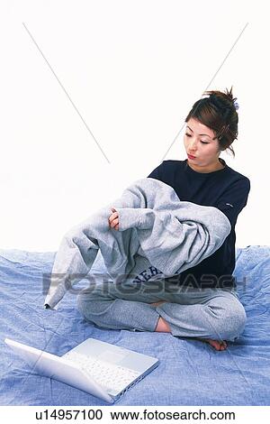Young Adult Woman Putting her Sweatshirt On, her Laptop In Front of her, High Angle View View Large Photo Image Stock Image - Young Adult Woman Putting her Sweatshirt On, her Laptop In Front of her, High Angle View. Fotosearch