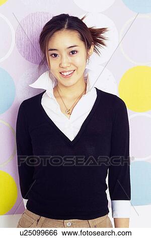 Young Adult Woman Standing In Front Of Polka Dot Wall, Smiling, Looking at Camera, Front View View Large Photo Image Stock Photograph - Young Adult Woman Standing In Front Of Polka Dot Wall, Smiling, Looking at Camera, Front View. Fotosearch