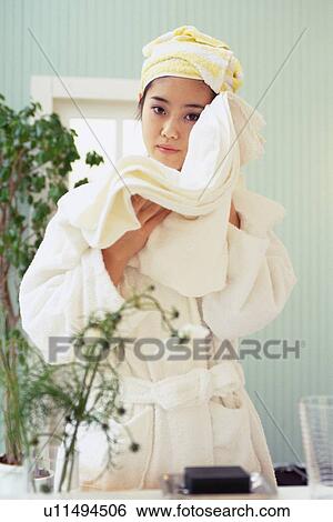 Stock Photograph - Young Woman Drying Her Face With White Bath Towel, Looking at Camera, Low Angle View. Fotosearch