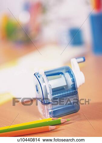 Picture - Colored pencils and pencil sharpener on table. Fotosearch
