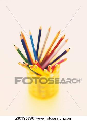 Stock Photograph - Colored pencils in orange penholder fanned out in a circle. Fotosearch