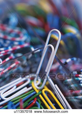 Stock Photo - Mass of colored clips in box, one leaning on edge. Fotosearch