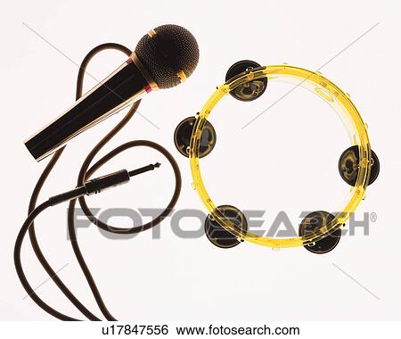 Stock Photograph - Tambourine and silhouette of microphone, high angle view, white background. Fotosearch