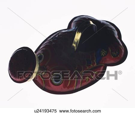 Stock Photography - Watering pot shaped like a goldfish, high angle view, white background. Fotosearch