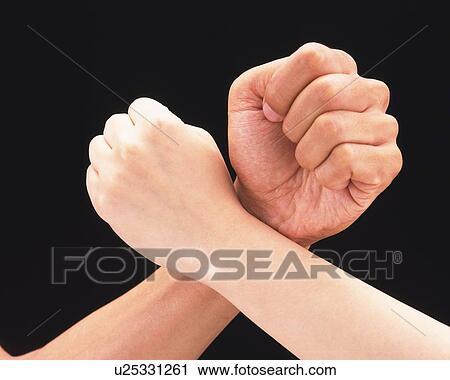 Stock Image - Man and woman crossing arms with fists. Fotosearch