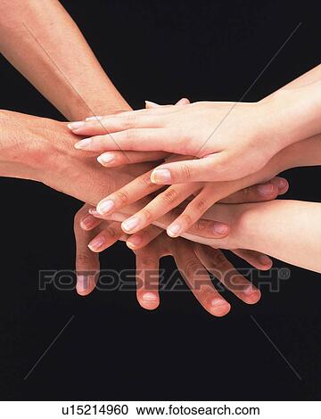 Stock Image - Three people piling hands. Fotosearch