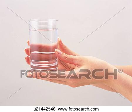 Woman holding a glass of water View Large Photo Image Stock Photo - Woman holding a glass of water. Fotosearch