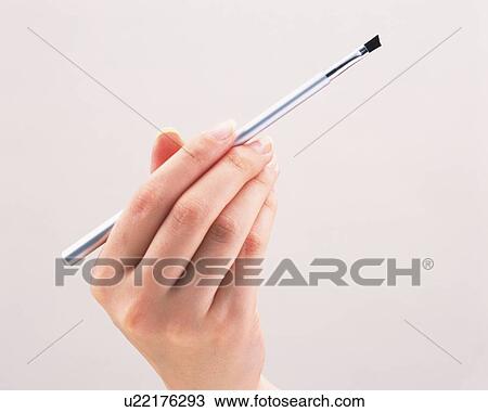 Stock Image - Woman holding a lip brush. Fotosearch