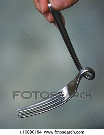 Picture - A person holding twisted fork. Fotosearch