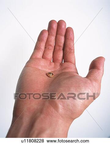 Stock Photo - A thumbtack put on human hand. Fotosearch