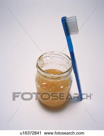 Blue toothbrush leaning on jam jar View Large Photo Image Stock Image - Blue toothbrush leaning on jam jar. Fotosearch