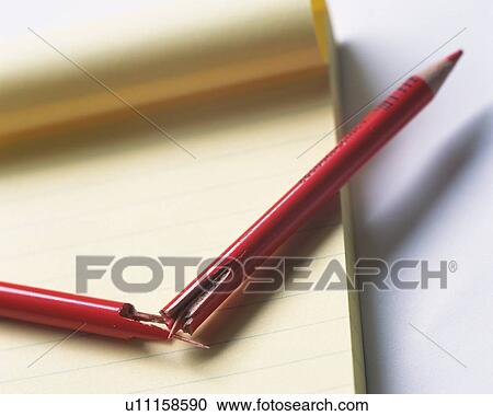 Stock Image - Broken red pencil on memo pad. Fotosearch