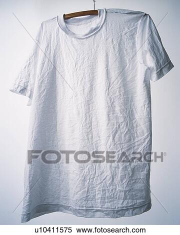 Stock Photography - Wrinkled T-shirt hung at white wall. Fotosearch