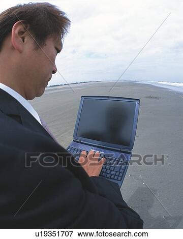 Stock Photo - Closed Up Image of a Businessman Using a Laptop at the Beach, High Angle View, Side View, Fish Eye. Fotosearch