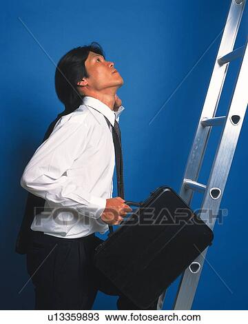Image of a Businessman About to Climb a Metallic Ladder With a Suitcase in his Hand, Looking Up, Side View View Large Photo Image Stock Image - Image of a Businessman About to Climb a Metallic Ladder With a Suitcase in his Hand, Looking Up, Side View. Fotosearch
