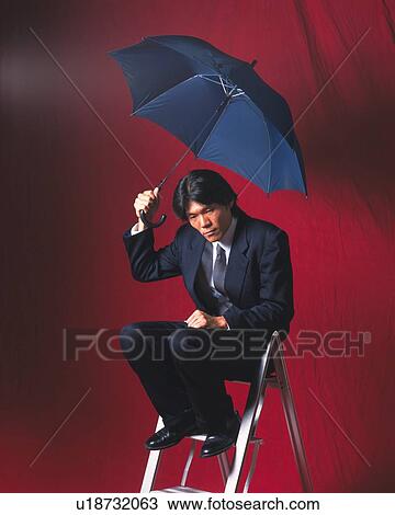 Stock Image - Image of a Businessman Sitting on a Stepladder, Holding an Umbrella With his Eyes Closed, Side View. Fotosearch