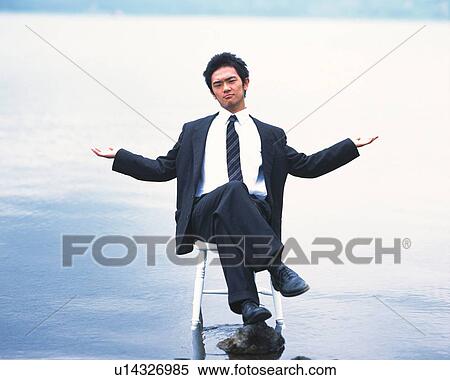 Image of a Businessman Sitting on a Chair on a Beach, His Arms Wide Open, Front View, Looking at Camera View Large Photo Image Stock Photography - Image of a Businessman Sitting on a Chair on a Beach, His Arms Wide Open, Front View, Looking at Camera. Fotosearch