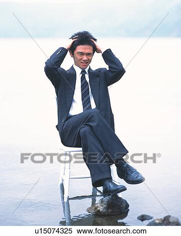 Image of a Businessman Sitting on a Stool While Tearing his Hair, Front View View Large Photo Image Stock Photography - Image of a Businessman Sitting on a Stool While Tearing his Hair, Front View. Fotosearch