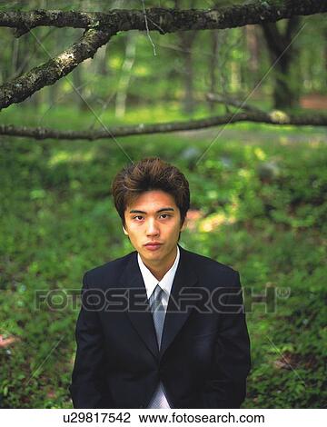Stock Image - Image of a Businessman Surrounded By Green, Looking at Camera, Front View, Differential Focus. Fotosearch