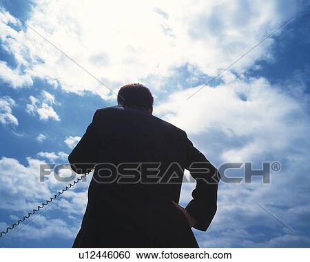 Image of a Businessman Talking on a Phone Under a Blue Sky, Low Angle View, Rear View View Large Photo Image Stock Image - Image of a Businessman Talking on a Phone Under a Blue Sky, Low Angle View, Rear View. Fotosearch