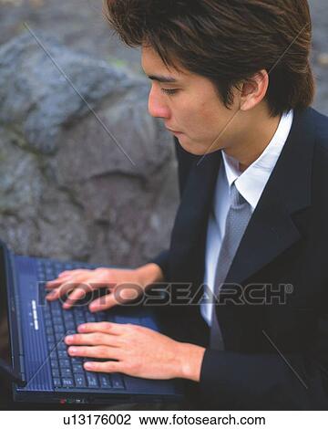 Stock Image - Image of a Businessman Working at his Computer, Looking Down, High Angle View, Side View. Fotosearch
