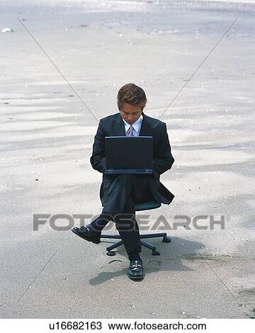 Image of a Businessman Working at His Laptop at the Beach While Sitting in an Office Chair, High Angle View View Large Photo Image Stock Image - Image of a Businessman Working at His Laptop at the Beach While Sitting in an Office Chair, High Angle View. Fotosearch