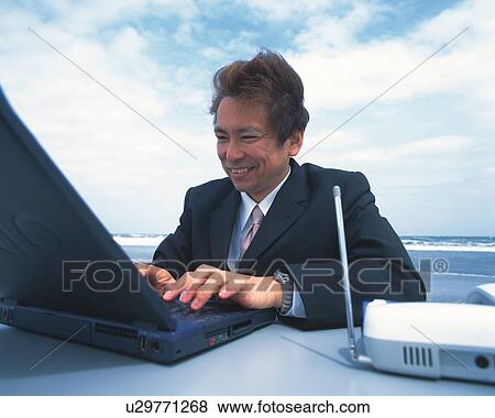 Image of a Businessman Working on his Laptop at the Beach, Smiling, Side View View Large Photo Image Stock Photo - Image of a Businessman Working on his Laptop at the Beach, Smiling, Side View. Fotosearch
