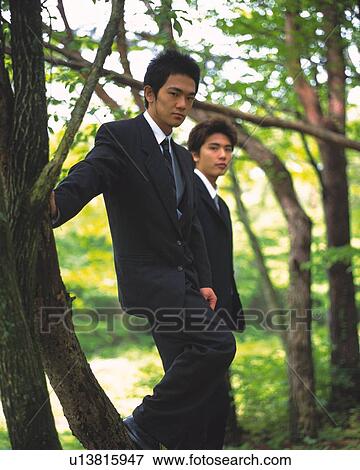 Stock Photo - Image of Two Businessmen Standing in the Woods, Surrounded By Green, Side View, Differential Focus. Fotosearch