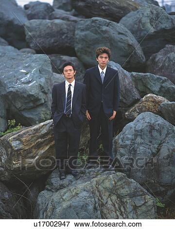 Image of Two Businessmen Standing on a Huge Rock, Front View, Looking at Camera View Large Photo Image Stock Photo - Image of Two Businessmen Standing on a Huge Rock, Front View, Looking at Camera. Fotosearch