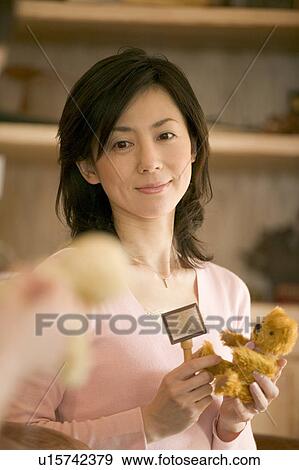 Stock Photo - Mid Adult Woman Holding a Teddy Bear. Fotosearch