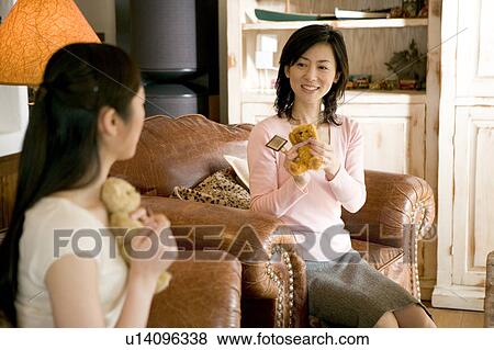 Stock Photo - Two Mid Adult Women Holding a Teddy Bear. Fotosearch