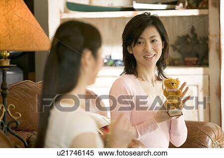 Stock Photography - Two Mid Adult Women Holding a Teddy Bear. Fotosearch