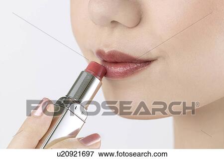 Young Woman Applying Lipstick View Large Photo Image Stock Photo - Young Woman Applying Lipstick. Fotosearch