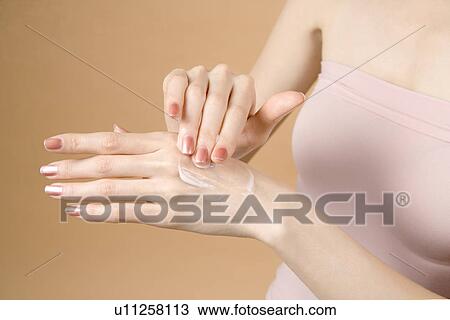 Stock Image - Young Woman Applying Moisturizer. Fotosearch