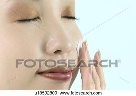 Young Woman Applying Moisturizer View Large Photo Image Stock Photo - Young Woman Applying Moisturizer. Fotosearch