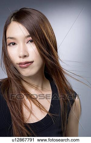 Young Woman Looking at Camera, Hair Blowing in Face View Large Photo Image Stock Image - Young Woman Looking at Camera, Hair Blowing in Face. Fotosearch