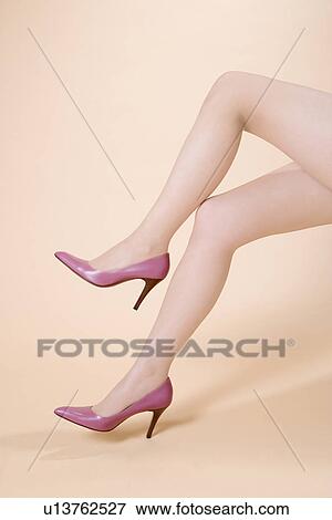 Young Woman, Sitting, Crossing Legs View Large Photo Image Stock Photo - Young Woman, Sitting, Crossing Legs. Fotosearch