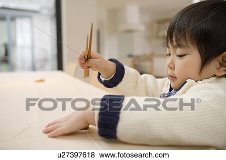 Stock Photo - Boy holding a pair of chopsticks. Fotosearch
