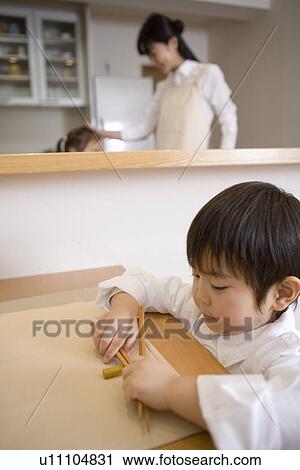 Stock Image - Boy preparing the table for the dinner. Fotosearch