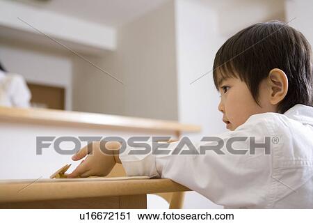 Boy preparing the table for the dinner View Large Photo Image Stock Image - Boy preparing the table for the dinner. Fotosearch
