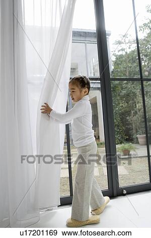 Girl closing a curtain View Large Photo Image Stock Photo - Girl closing a curtain. Fotosearch