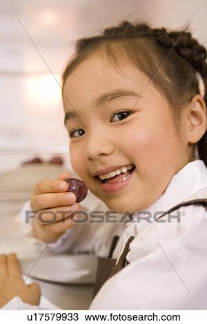 Girl eating a grape View Large Photo Image Stock Image - Girl eating a grape. Fotosearch