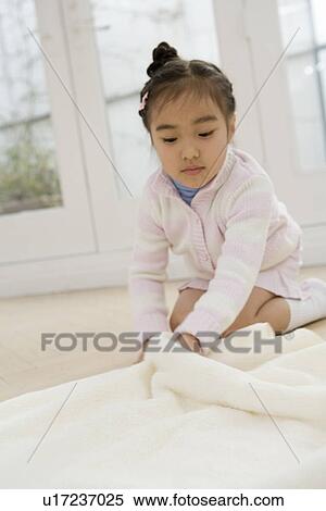 Girl folding a clean towel View Large Photo Image Stock Photography - Girl folding a clean towel. Fotosearch